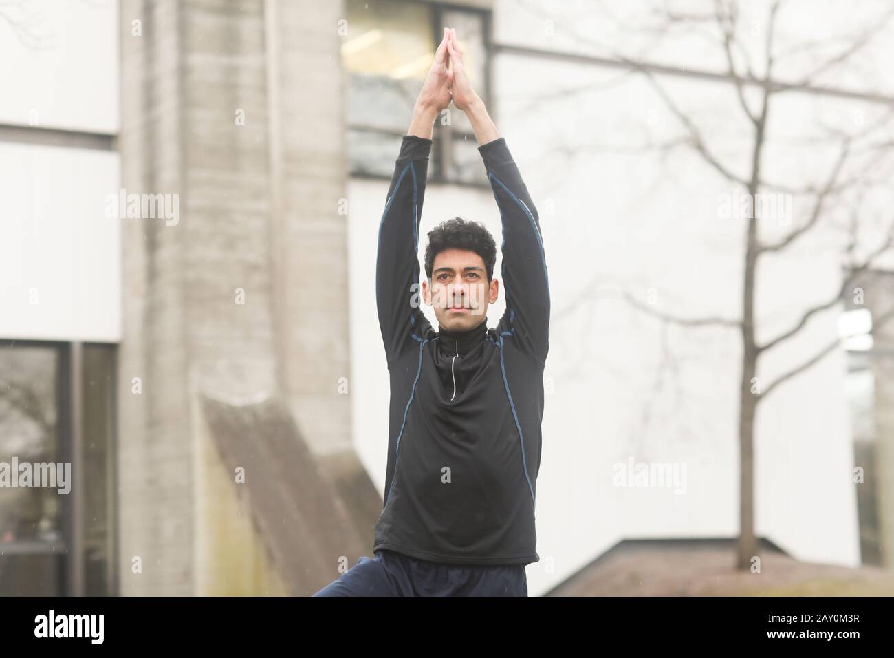 Ritratto di un uomo che si alza fuori facendo yoga, Germania Foto Stock