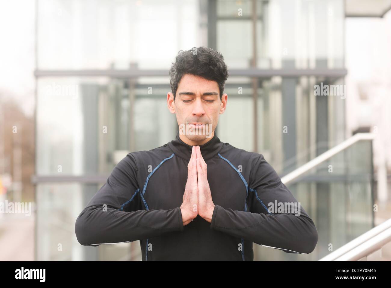 Ritratto di un uomo che si alza fuori facendo yoga, Germania Foto Stock