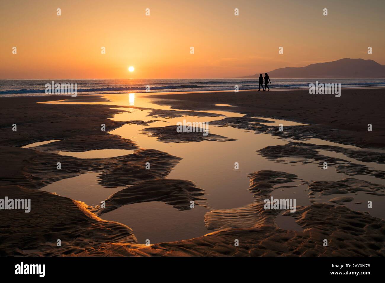 Silhouette di due donne che camminano sulla spiaggia al tramonto, Tarifa, Cadice, Andalusia, Spagna Foto Stock