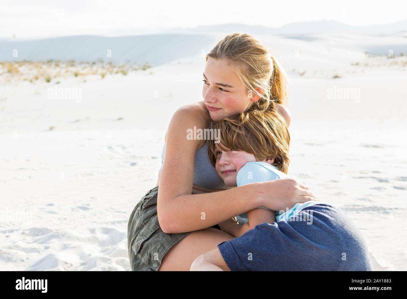 Ragazza teen abbracciando suo fratello, White Sands Nat'l Monument, NM Foto Stock