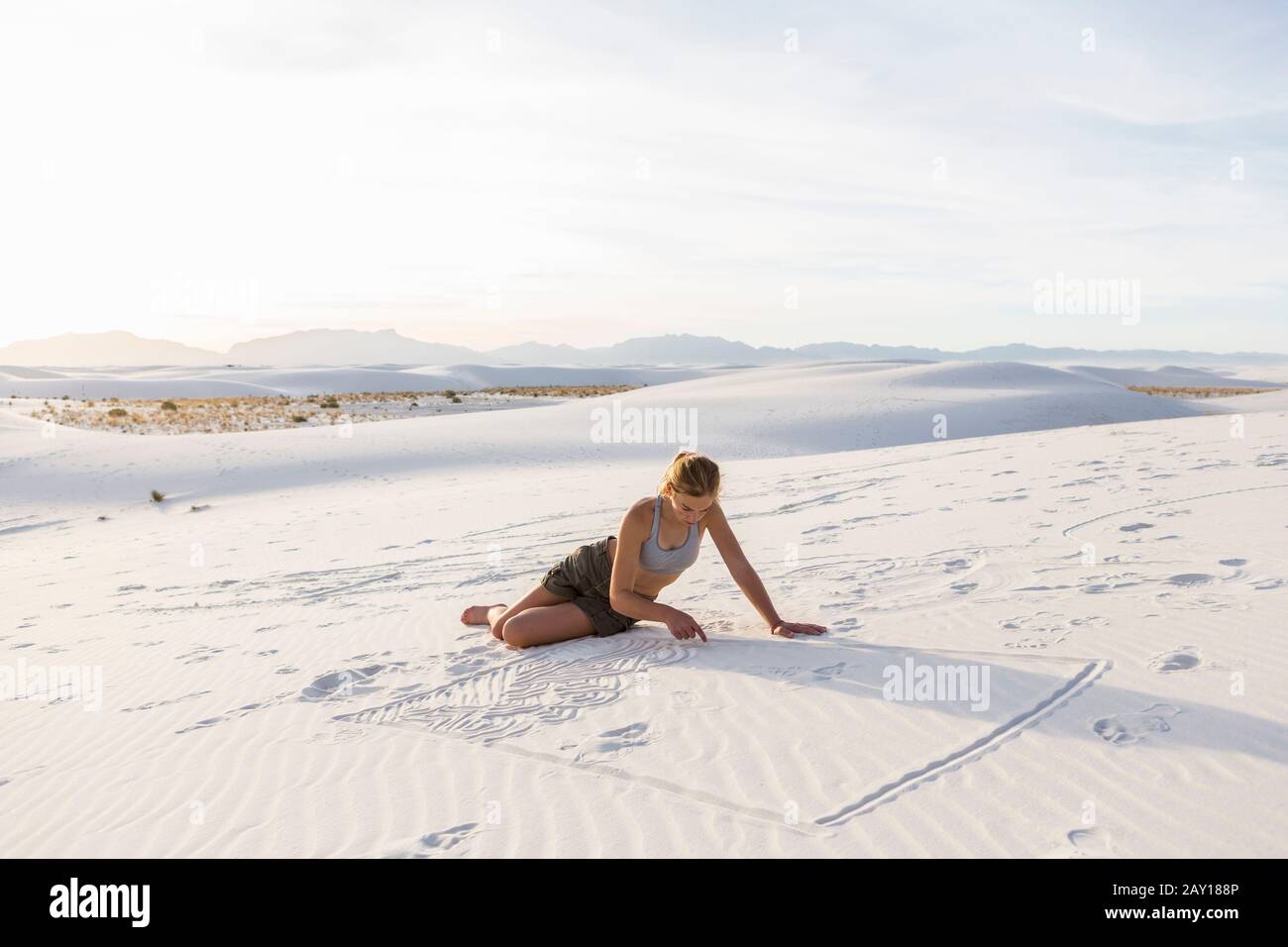 Ragazza di 13 anni che disegna nella sabbia, White Sands Nat'l Monument, NM Foto Stock