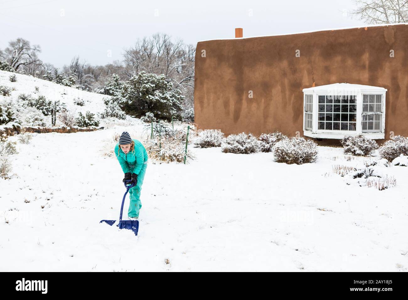 Ragazza teenage di tredici anni che costruisce un pupazzo di neve Foto Stock
