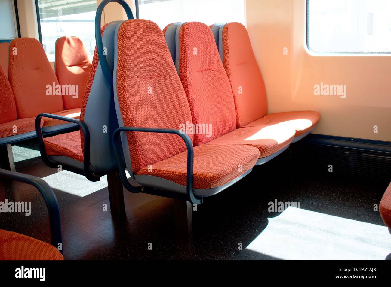 All'interno di una cabina ferroviaria con sedili arancioni e luce solare che entra attraverso i finestrini Foto Stock