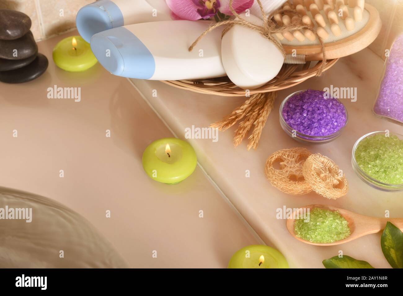 Prodotti per la cura della pelle in bagno. Gel, shampoo e sali e attrezzi da bagno nel cesto accanto a una vasca idromassaggio piena d'acqua. Vista elevata. Compo. Orizzontale Foto Stock