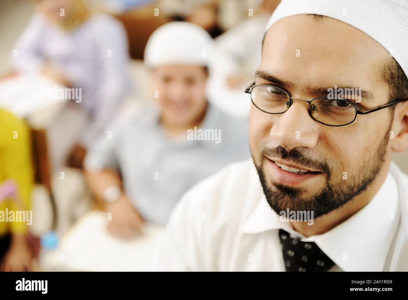 Insegnante in Medio Oriente in classe scolastica con bambini in background Foto Stock