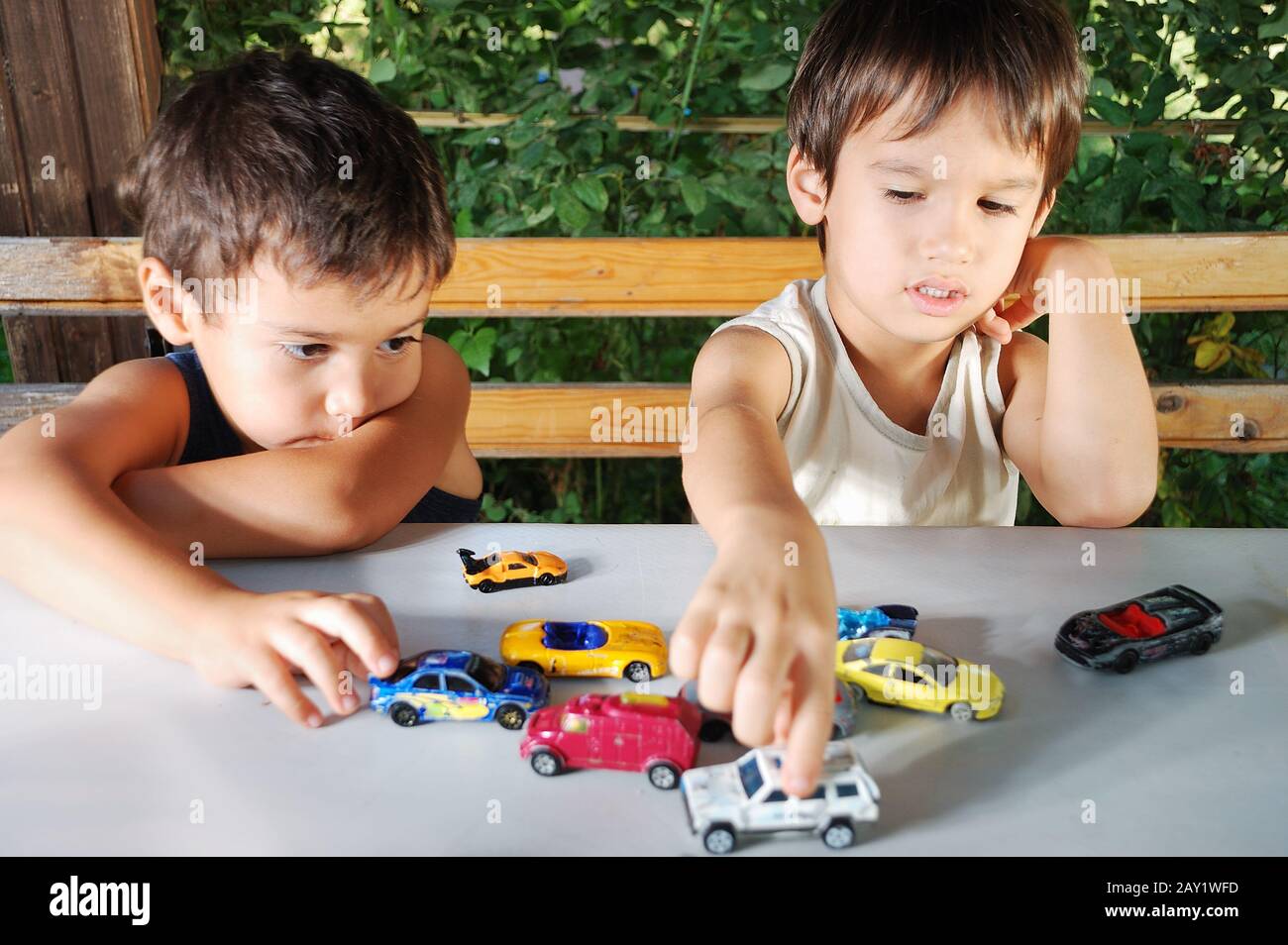 Bambini che giocano con giocattoli auto all'aperto in estate Foto Stock