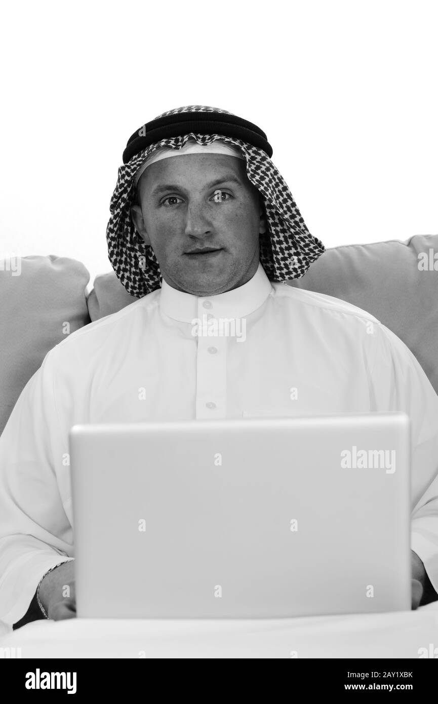 Uomo arabo che usa il laptop a casa Foto Stock
