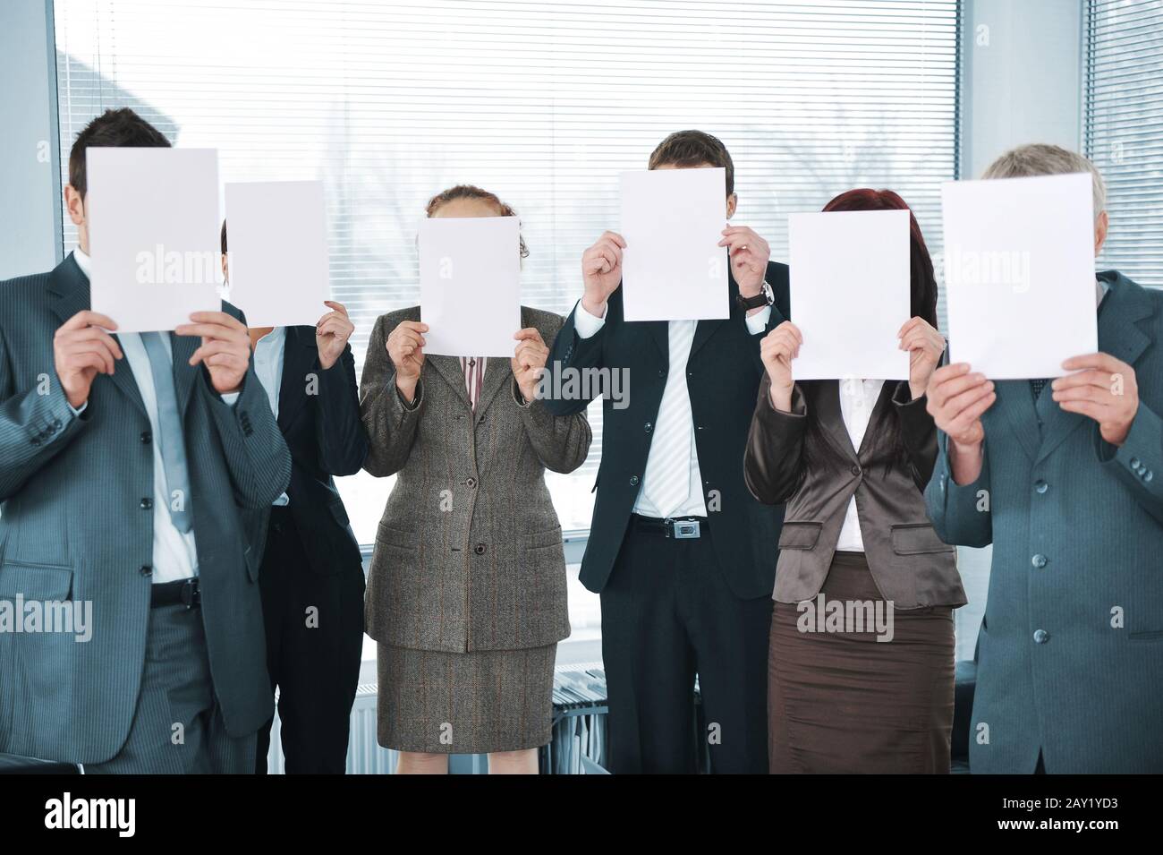 Team aziendale che tiene white paper in ufficio Foto Stock