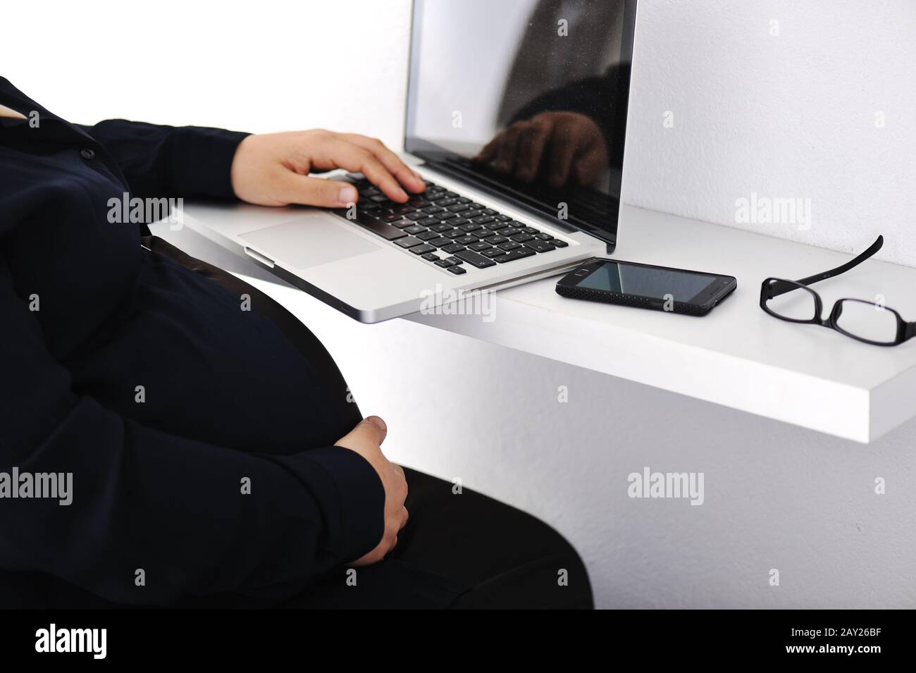 Donna d'affari musulmana incinta che usa un computer portatile Foto Stock