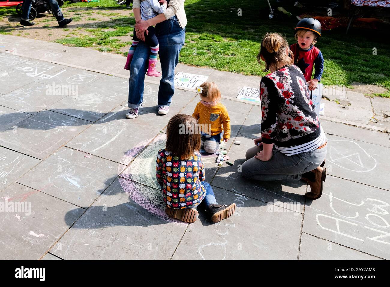 Londra, Regno Unito. I bambini disegnano un arcobaleno sul pavimento con il gesso mentre Londra si ferma come manifestanti con il velcro di protesta di ribellione di estinzione Foto Stock