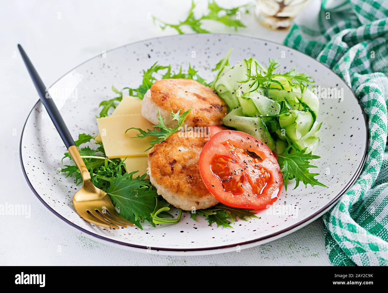 Pranzo chetogenico. Hamburger di pollo con pomodoro, cetriolo, formaggio e insalata di rucola senza bun. Polpette di pollo. Cibo sano. Dieta keto/paleo. Foto Stock