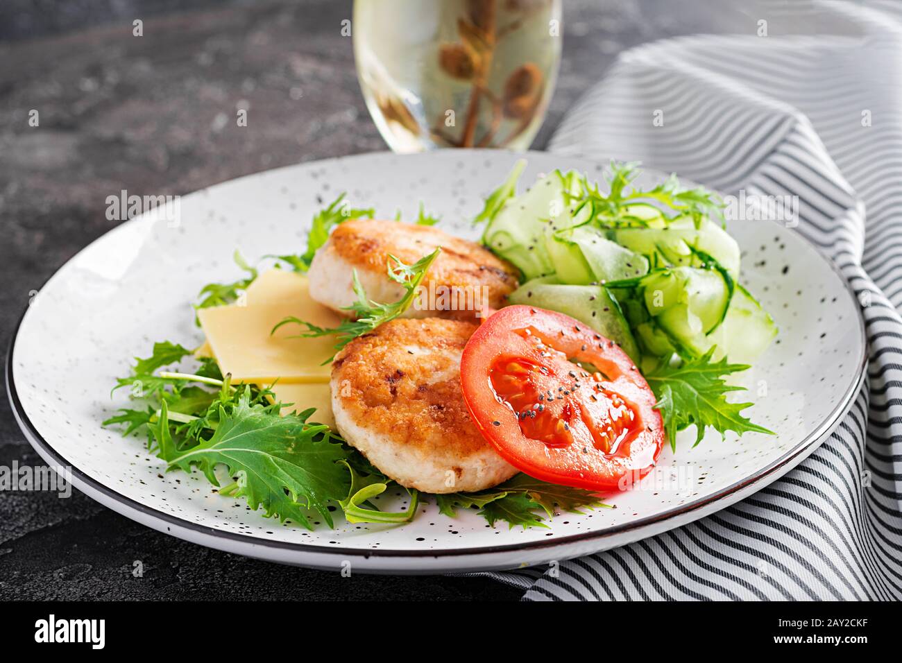 Pranzo chetogenico. Hamburger di pollo con pomodoro, cetriolo, formaggio e insalata di rucola senza bun. Polpette di pollo. Cibo sano. Dieta keto/paleo. Foto Stock