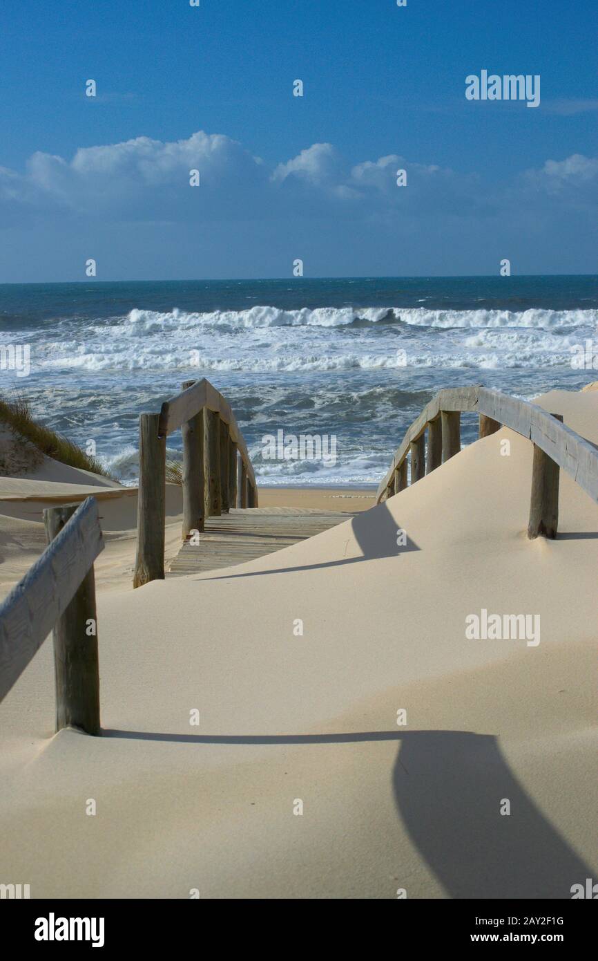 Vista mare da sogno da un passaggio di legno coperto di sabbia fine Foto Stock