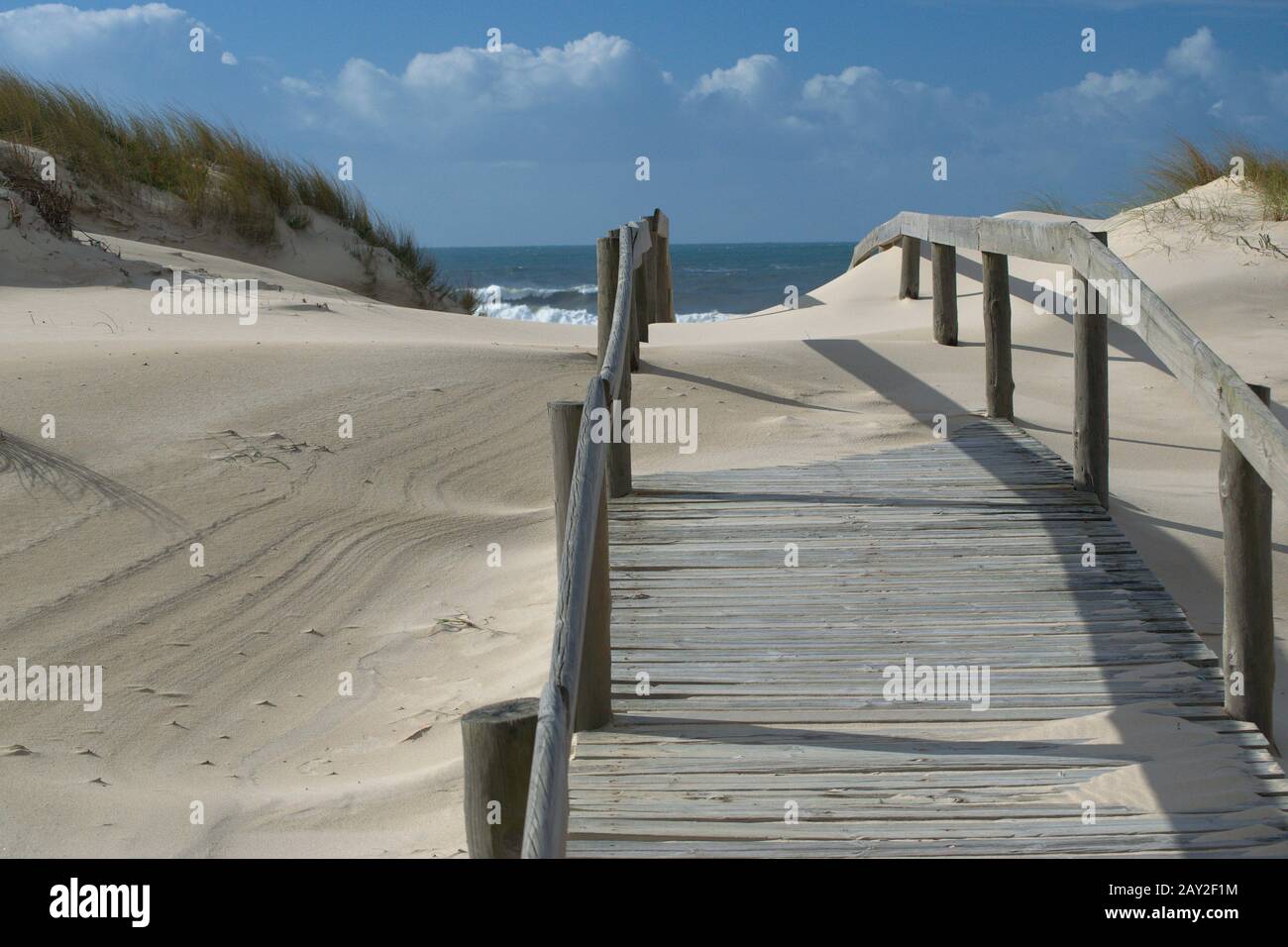 Idilliaco pass in legno circondato da sabbia marina con vista sul mare Foto Stock
