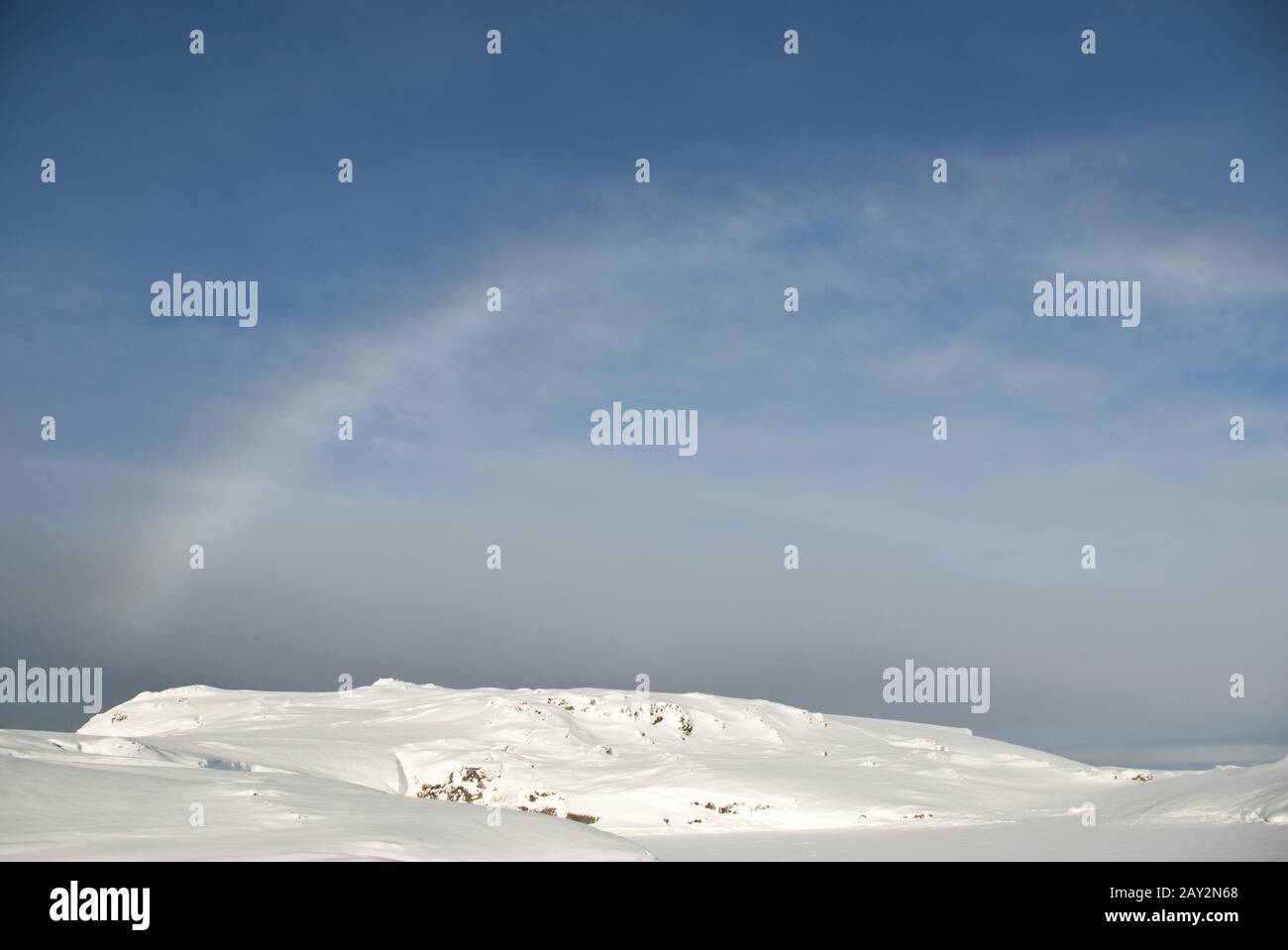 Arcobaleno sopra le isole Antartiche coperte di neve. Foto Stock