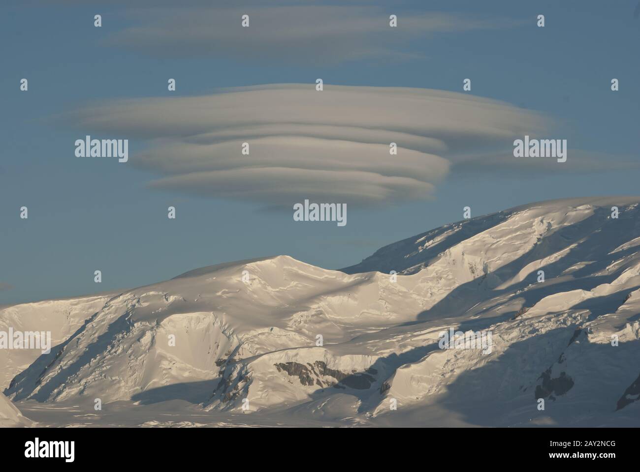 Inusuale nuvola a forma di UFO sopra le montagne Antartiche giorno d'inverno. Foto Stock