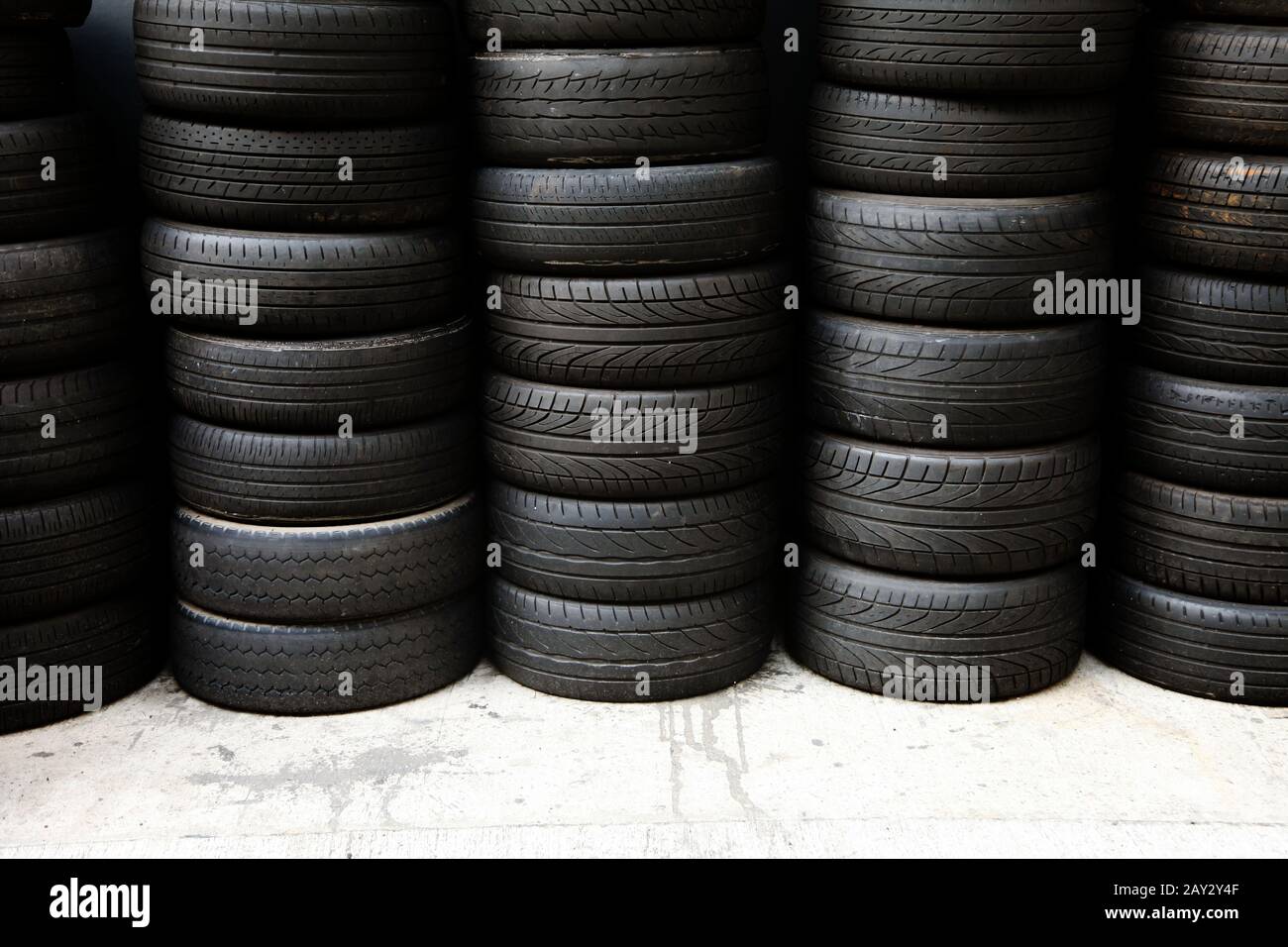 Stoccaggio pieno di nuovi pneumatici in ordine da colonne & file in un garage Foto Stock