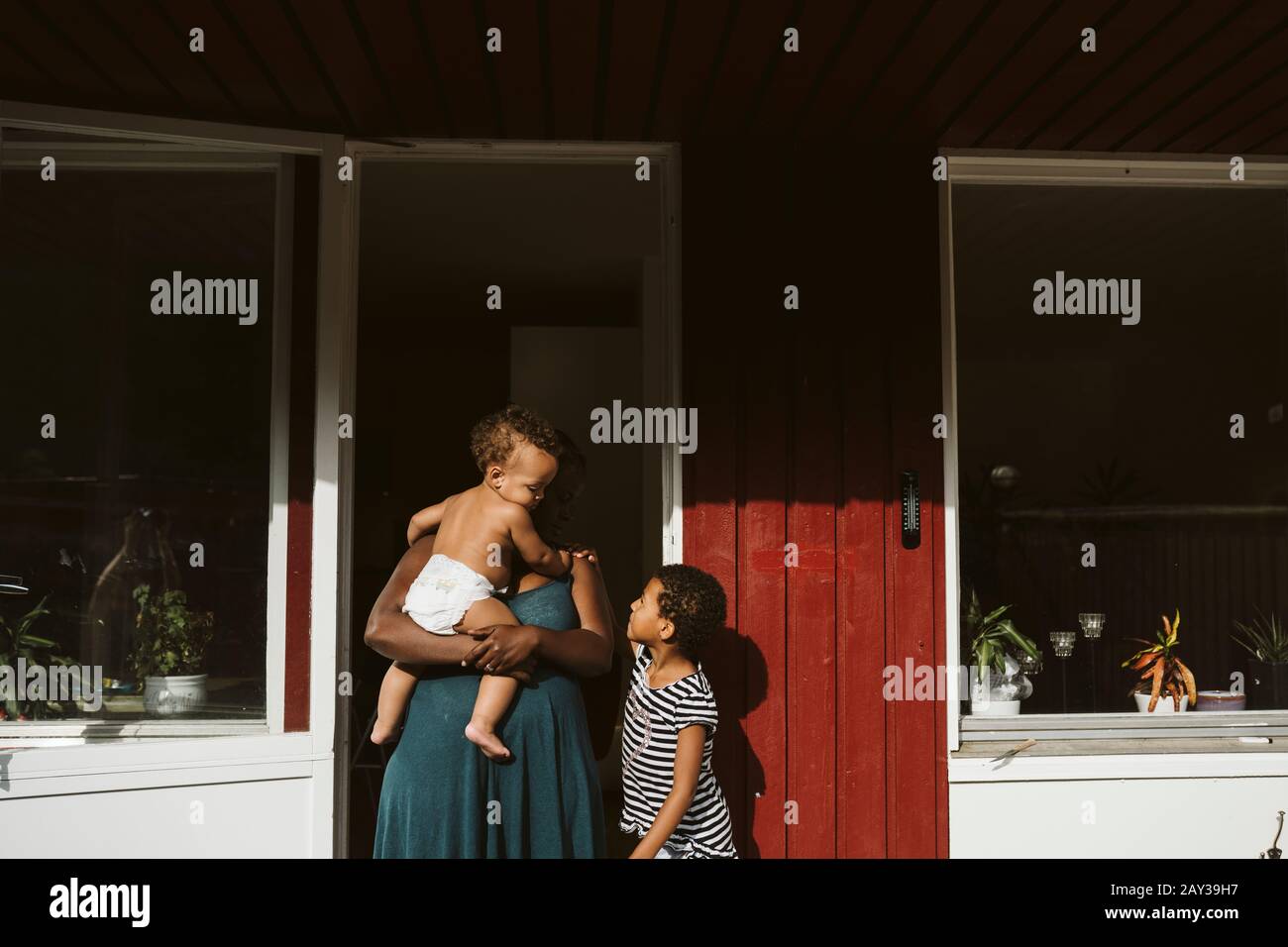 Madre con figli di fronte a casa Foto Stock