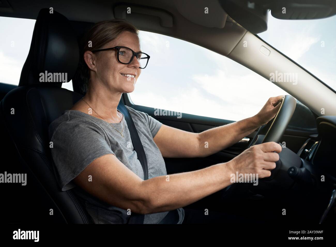Donna sorridente auto pilotaggio Foto Stock