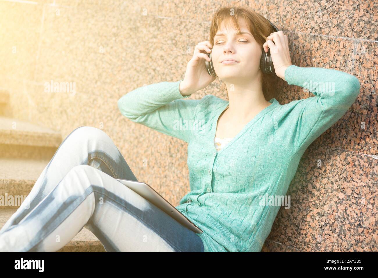 Bella donna giovane studente con le cuffie. Musica all'aperto ragazza Foto Stock