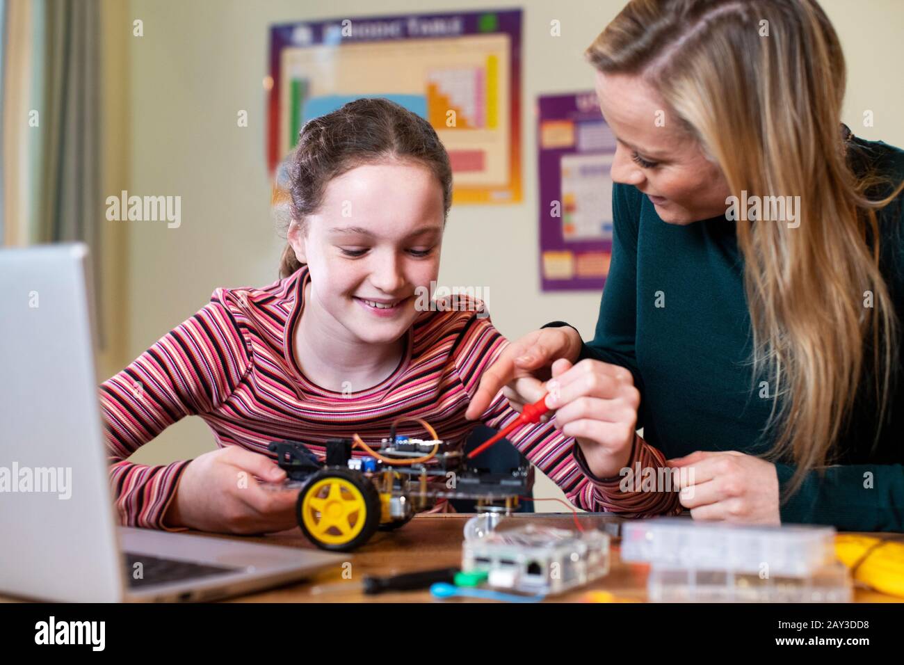 Insegnante Femminile Che Aiuta La Ragazza A Costruire L'Auto Robotica Nella Lezione Di Scienza Foto Stock