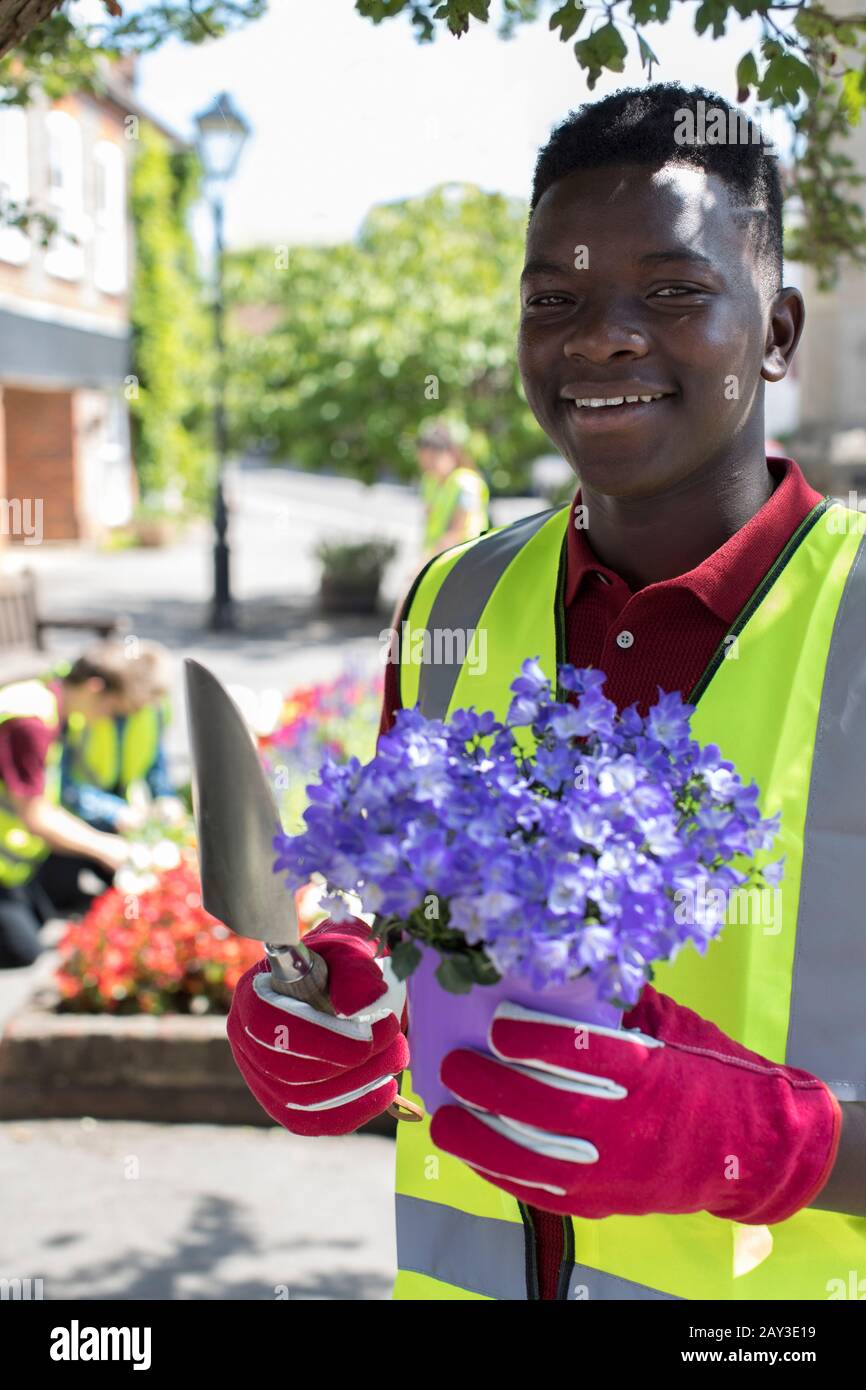 Gruppo di adolescenti utile piantagione e riorganizzati comunale letti di fiori Foto Stock