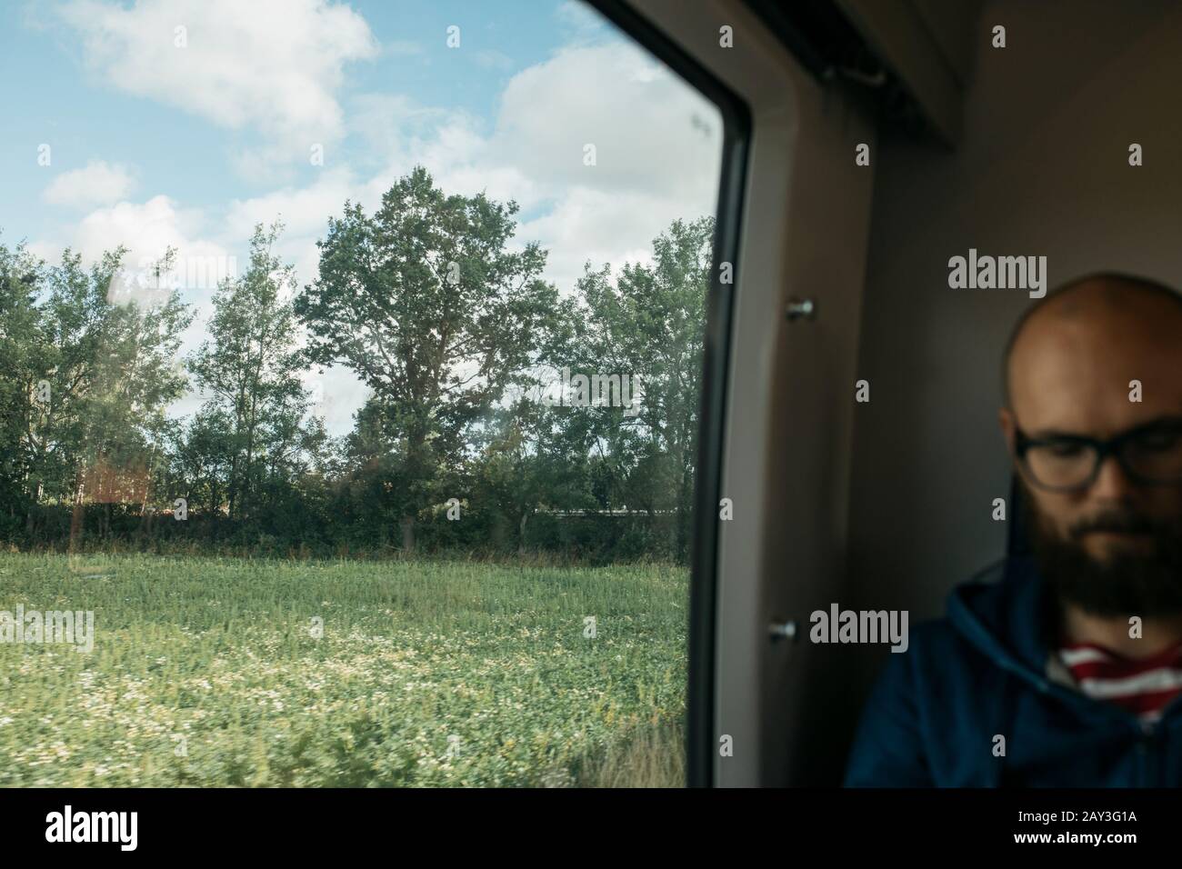 Paesaggio rurale dietro la finestra del treno Foto Stock