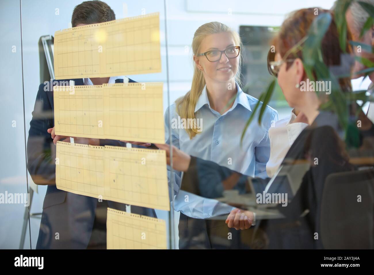 Il brainstorming del team di affari con i lotti delle note su un muro Foto Stock