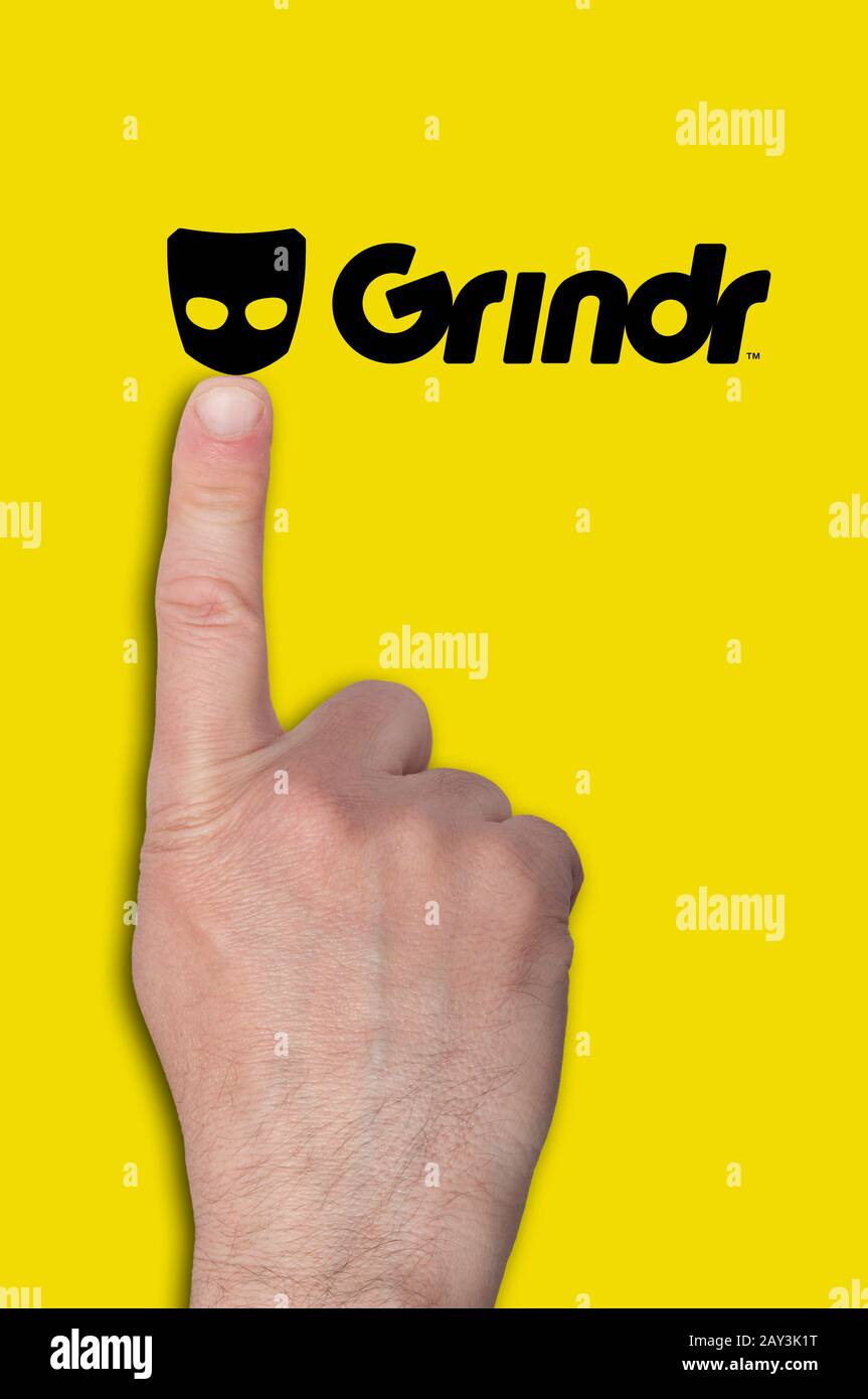 Toccare a mano un logo Grindr Foto Stock