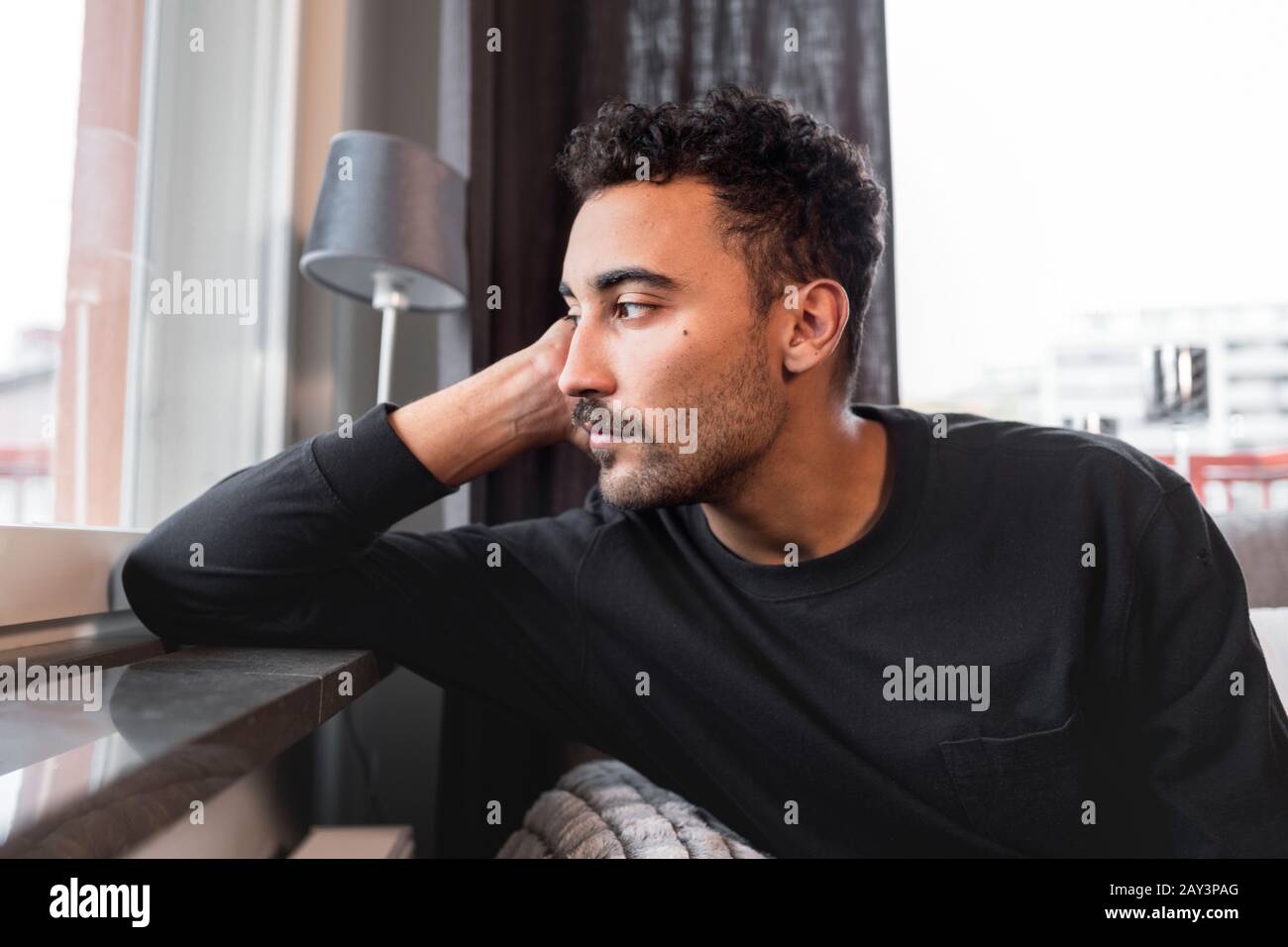 Uomo che guarda attraverso la finestra Foto Stock