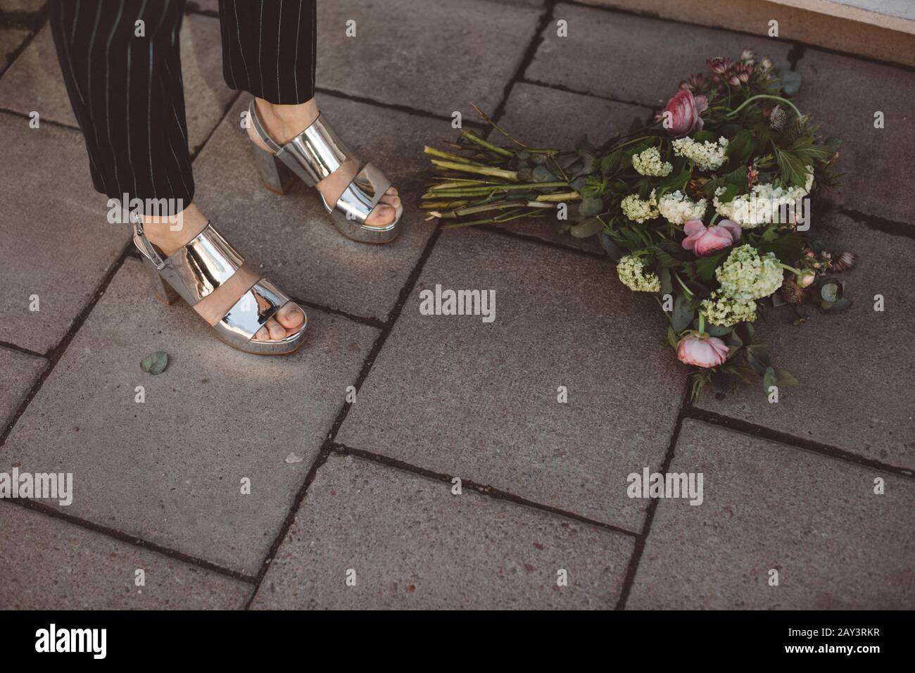 Donna in piedi vicino bouquet di fiori, sezione bassa Foto Stock