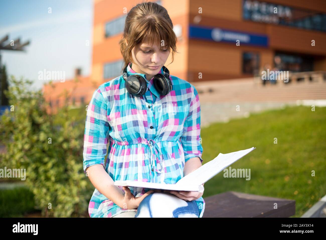 Studente ragazza con copybook sul banco di lavoro. Campus estivo di parco. Foto Stock