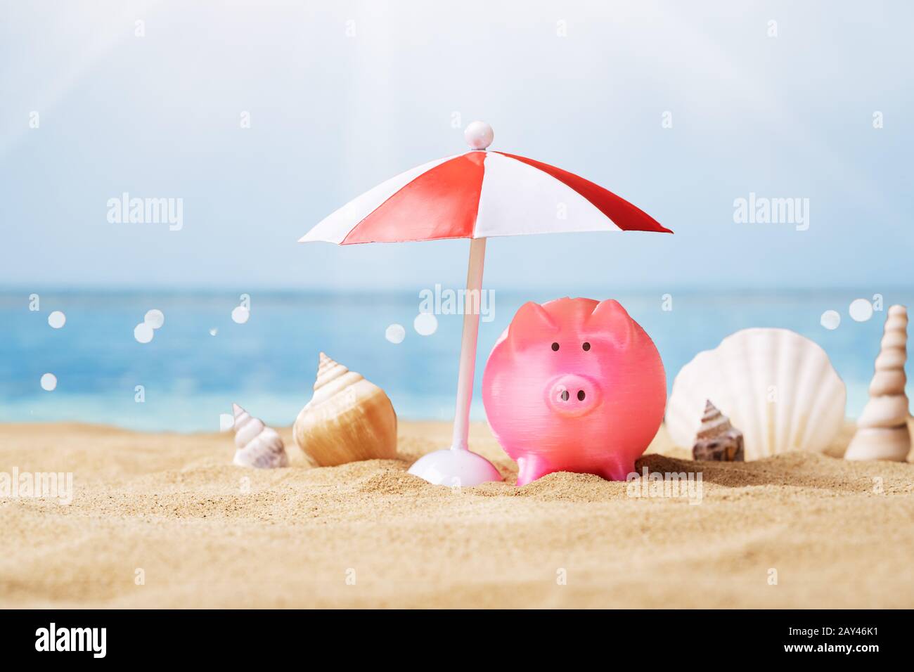 Rosa Salvadanaio sotto il piccolo Parasol durante l estate in spiaggia Foto Stock