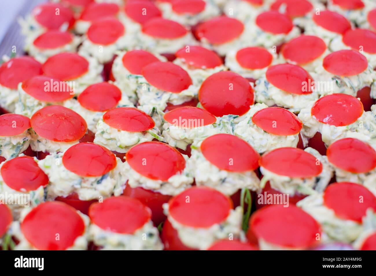 Tutto il mazzo di Tomatte Crevette, pomodori ripieni di gamberetti e insalata, su un buffet in un ambiente festoso Foto Stock