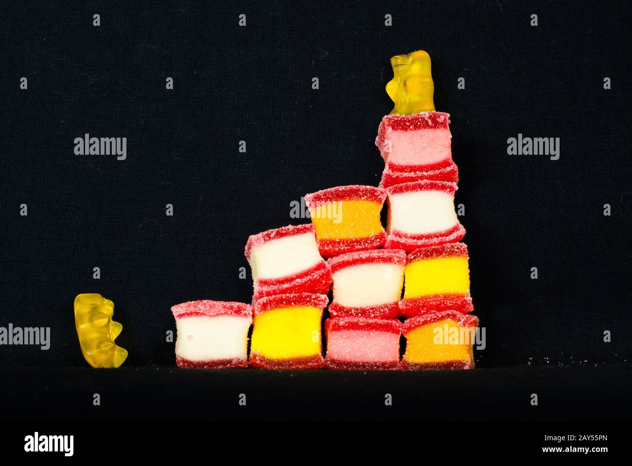 Due orsi di gomma del vino stanno salendo su alcune caramelle colorate Foto Stock