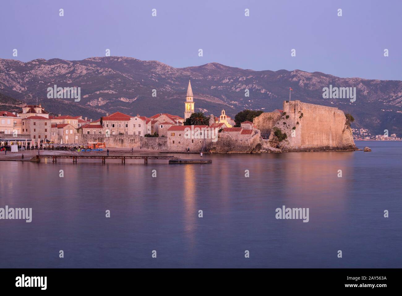 Tramonto sulla cittadella di Budva sul mare Adriatico. Fuori dalle mura della città si trova la spiaggia e il molo della città vecchia. Montenegro. Foto Stock
