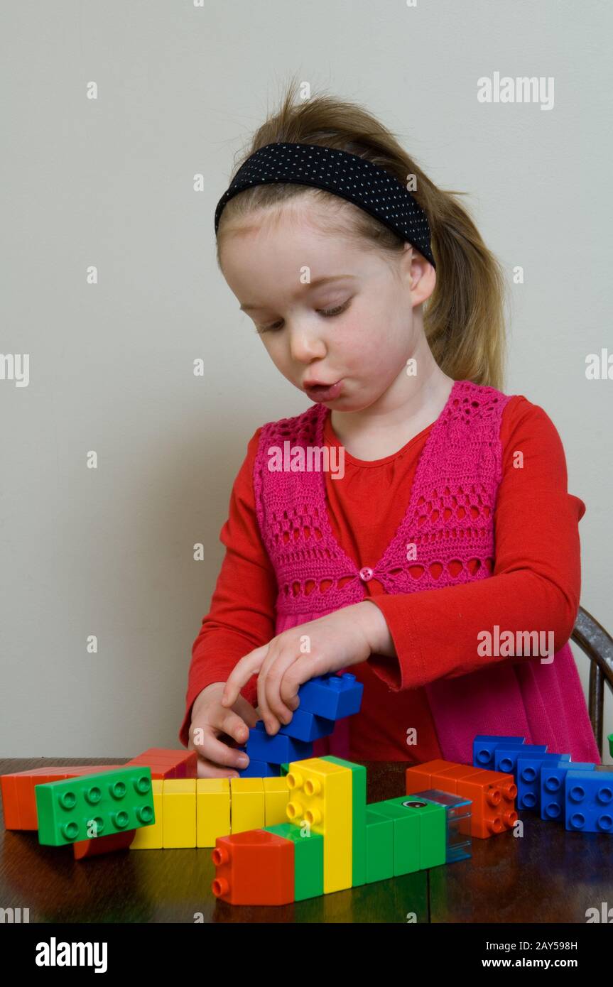 ragazza giovane che gioca con ligo Foto Stock