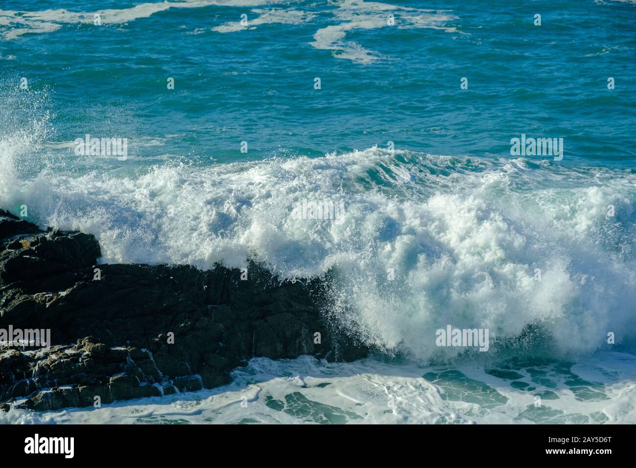Onde che si infrangono sulla costa rocciosa Foto Stock