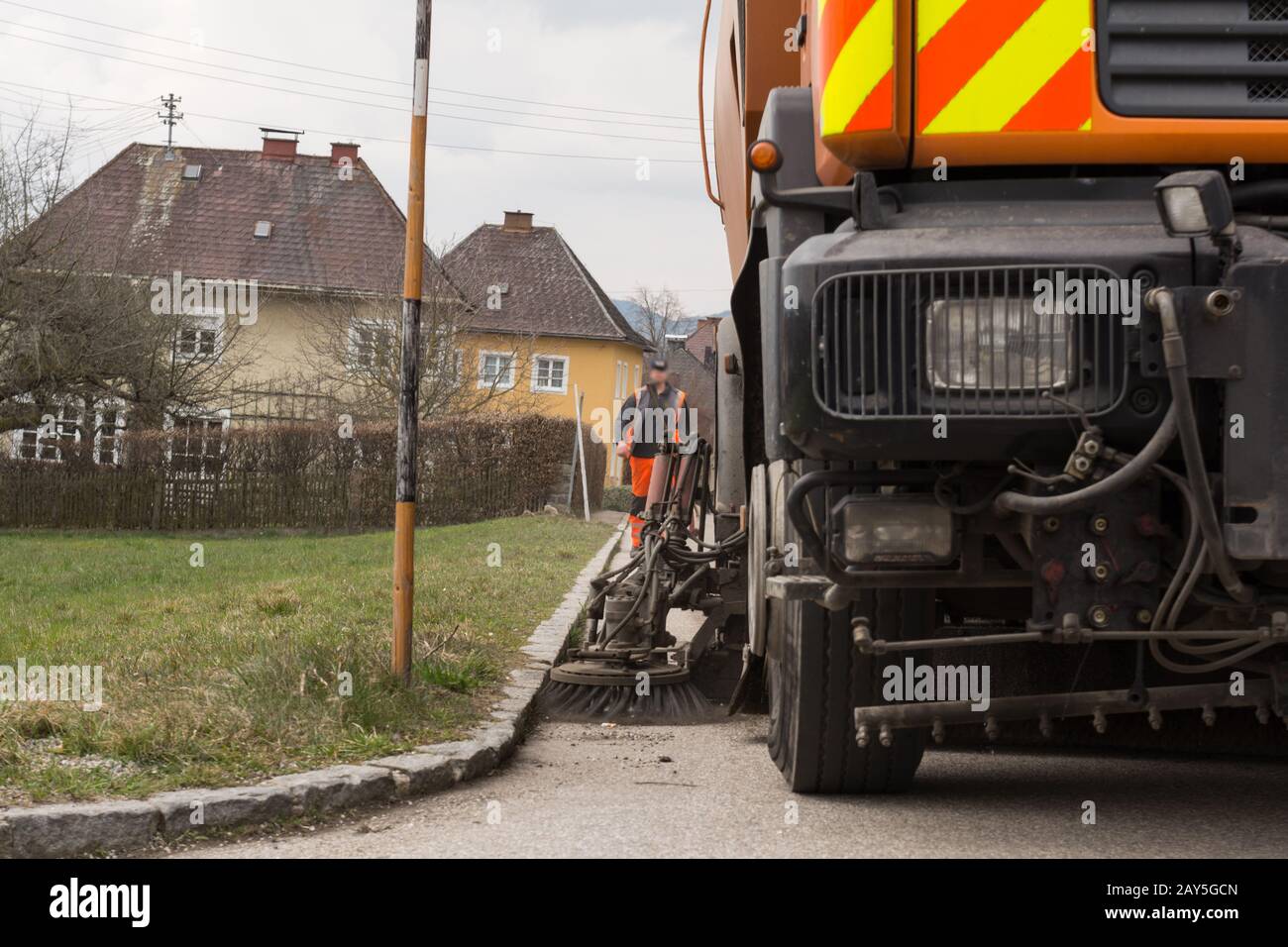 Spazzatrice stradale durante la pulizia a molla - il bordo della strada viene pulito Foto Stock