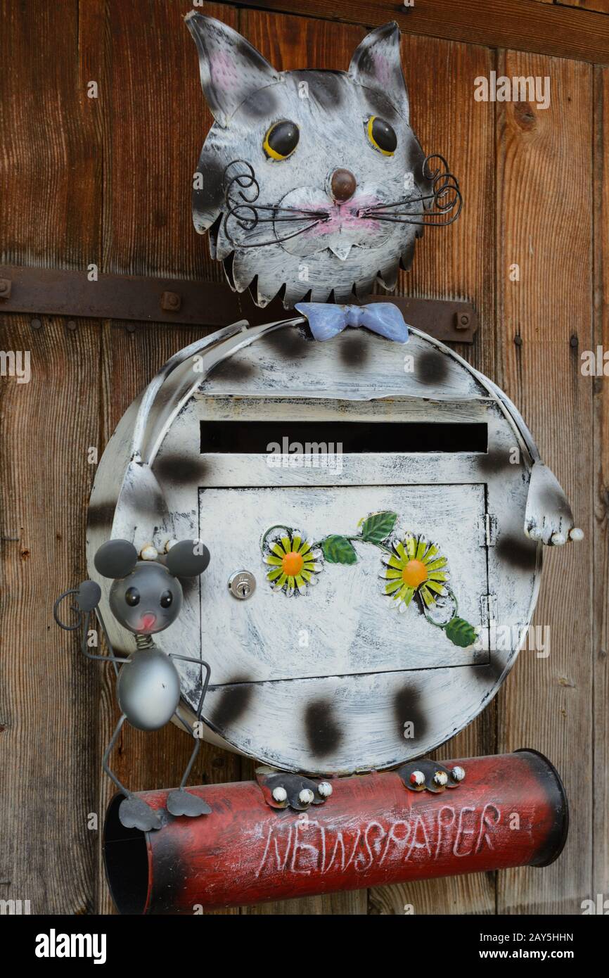 mailbox creativa sotto forma di gatto e mouse con rotolo di giornale Foto Stock