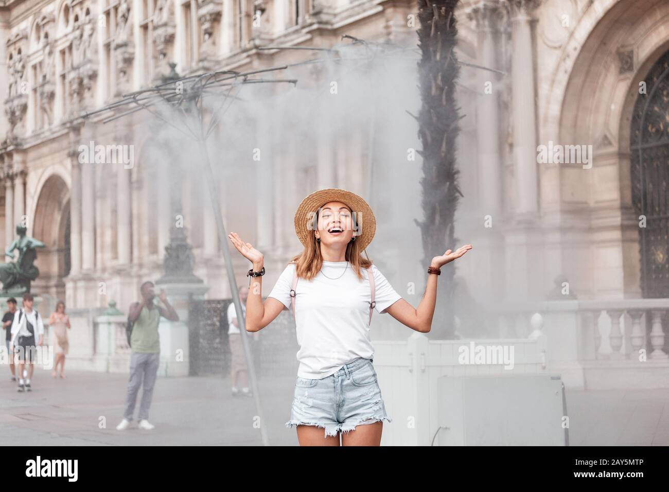 In condizioni climatiche estreme d'estate in Europa le persone passano sotto la nebbia degli umidificatori e godono della vita. Riscaldamento globale e raffreddamento Foto Stock