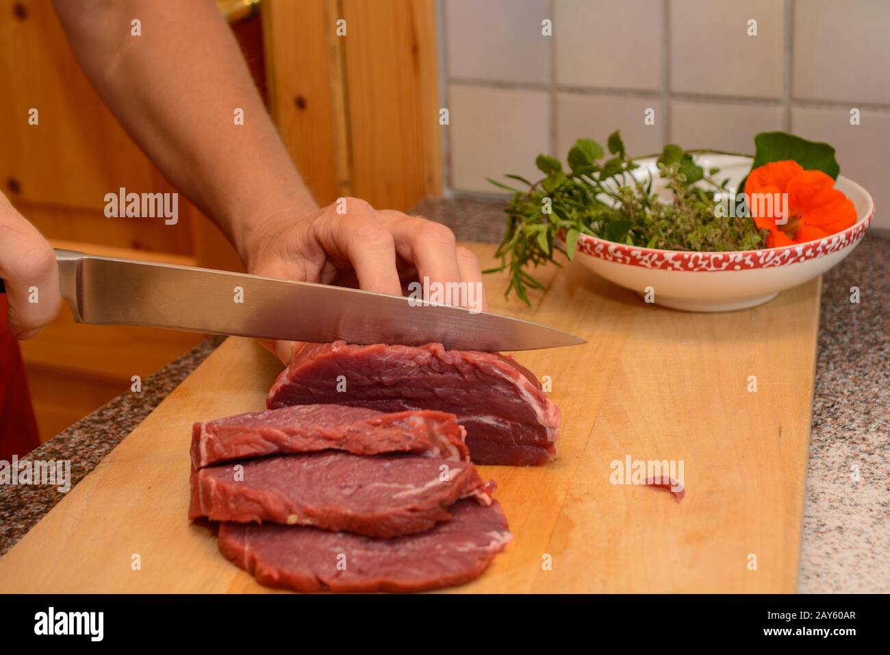 La persona taglia il manzo tenero in fette - bistecca di groppa Foto Stock