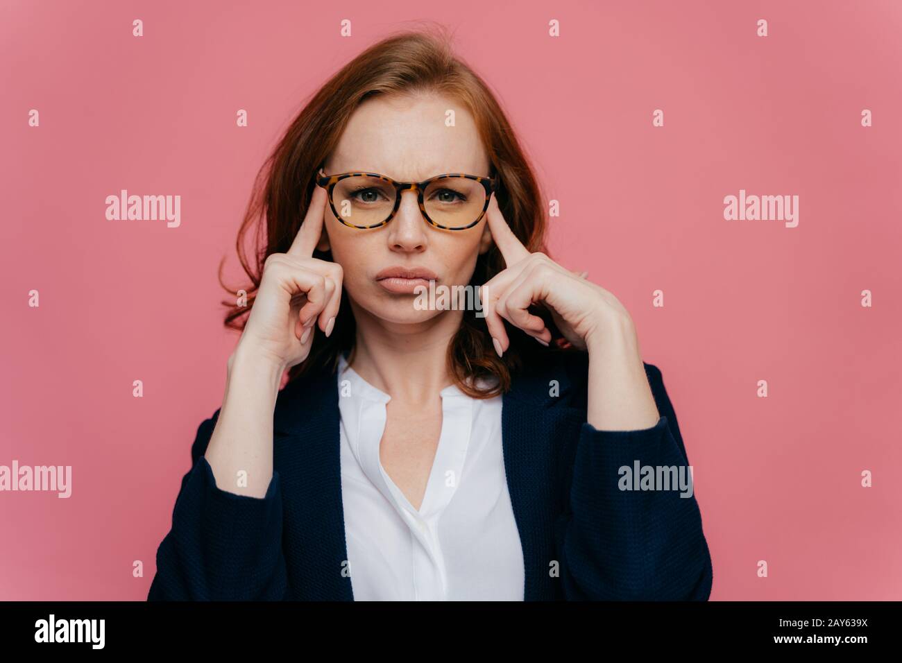 Ritratto di intensa bella signora tocca templi con entrambe le mani, cerca di ricordare qualcosa di importante in mente, ha serio concentrato guardare c Foto Stock