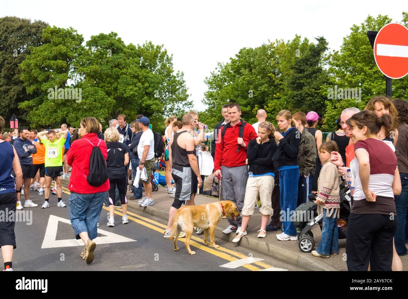Gruppi di persone e la raccolta di guide in strada prima di iniziare a 10km carità eseguire Foto Stock