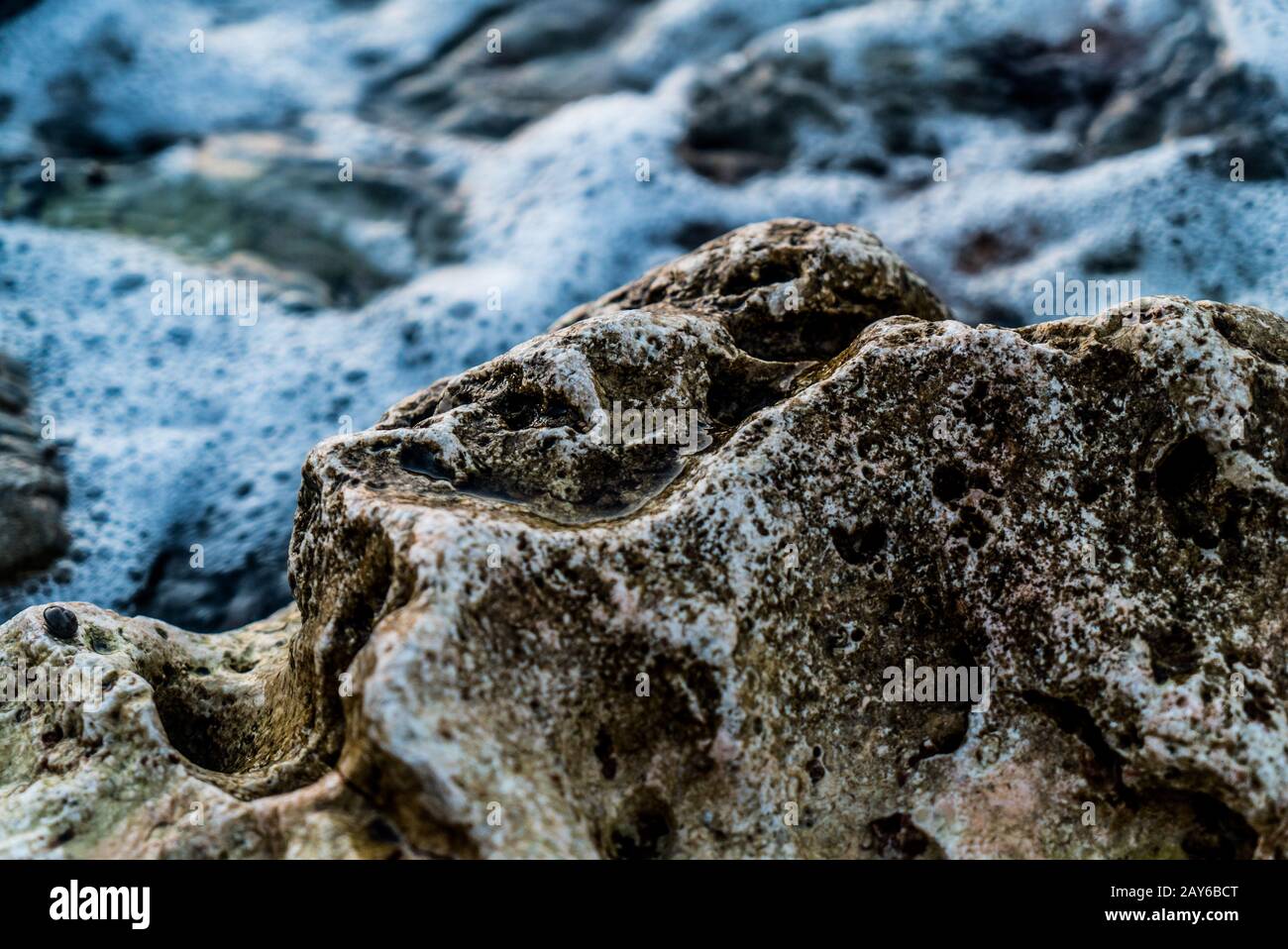 Close Up pietra nell'oceano, onda schiantosa Foto Stock