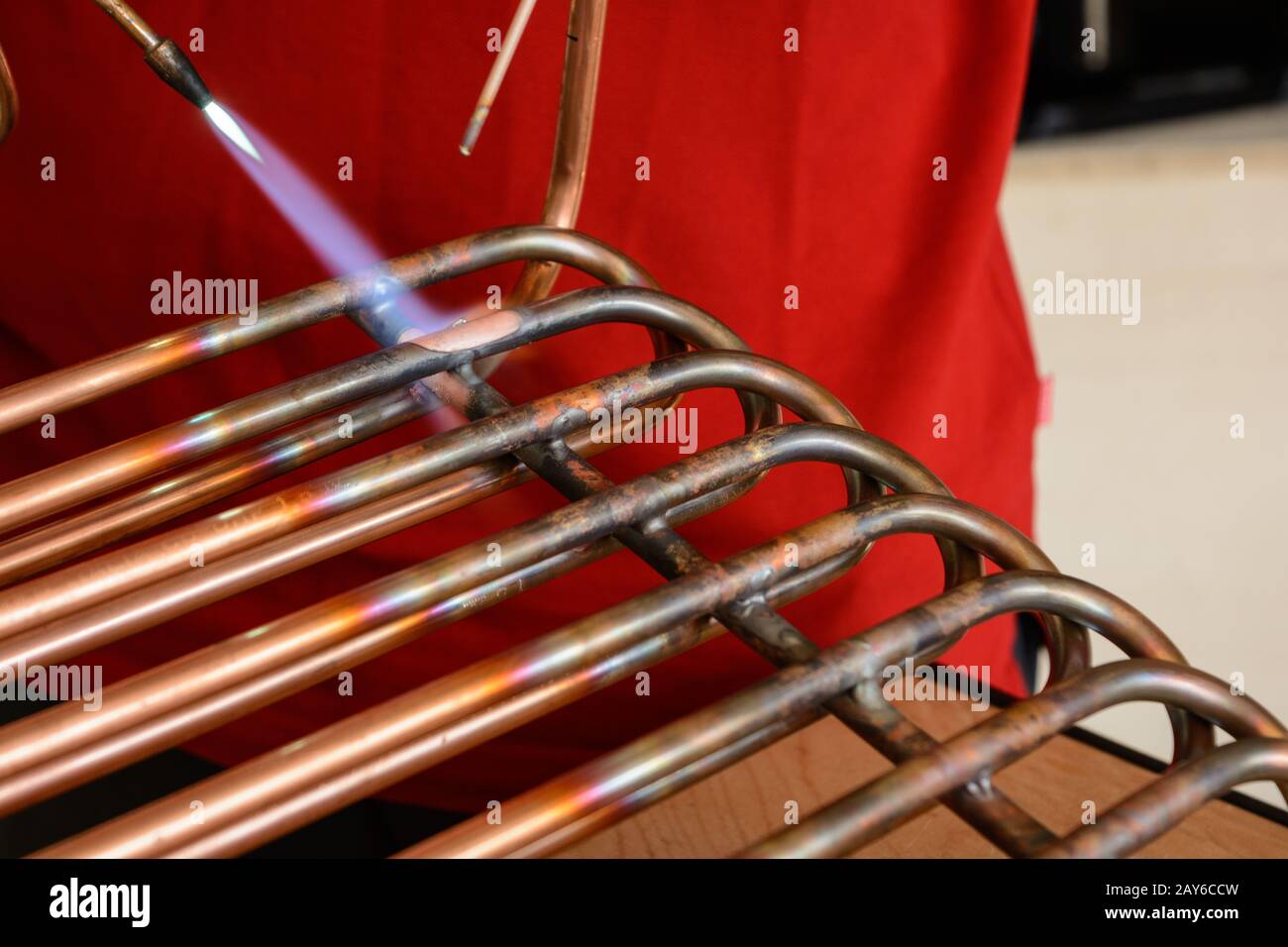 Un lavoratore esperto unisce i tubi di rame durante la brasatura - primo piano Foto Stock