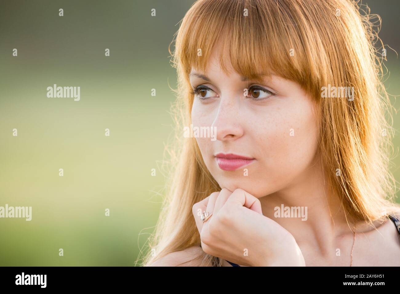 Su ritratto di una ragazza guardando a sinistra, creando un morbido sfondo verde Foto Stock