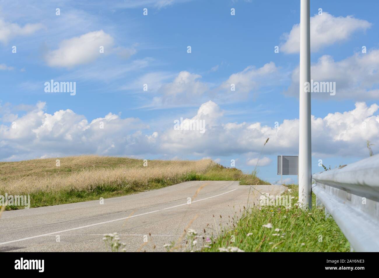 La strada con linea di barriera e la barriera di collisione termina come un punto morto Foto Stock