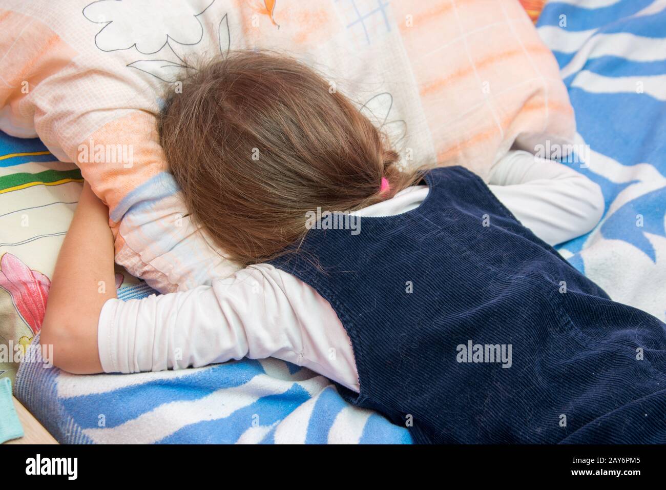 Sconvolto bambina piangendo con il suo volto sepolto nel cuscino Foto Stock