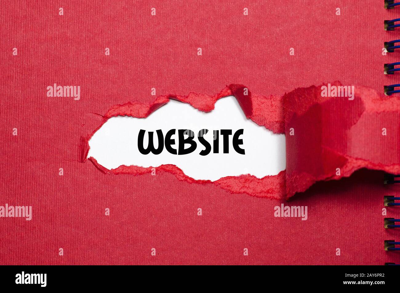 Il sito web di parola che appare dietro la carta strappata Foto Stock
